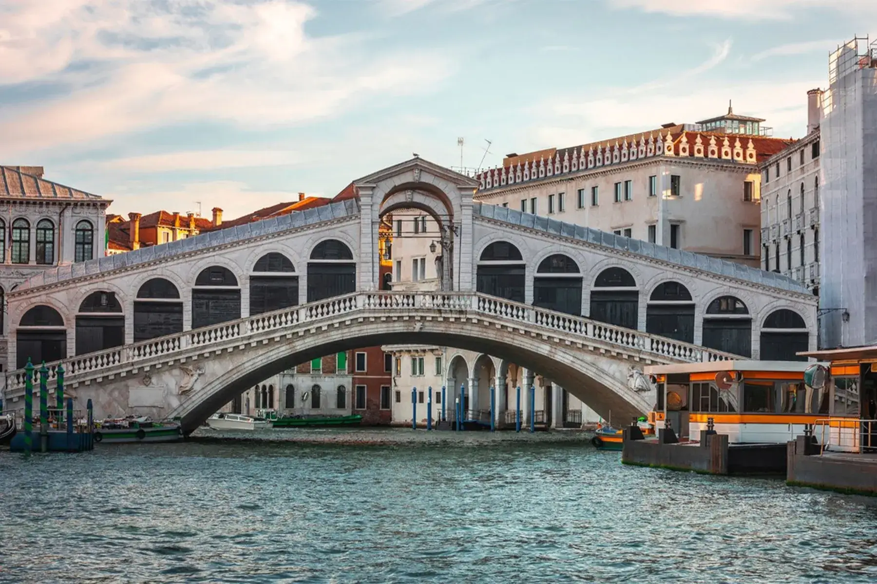 Il Ponte di Rialto, un arco in pietra a Venezia, in Italia, attraversa il Canal Grande tra edifici storici.