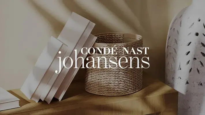 Libri, cestino e scultura su legno con testo Condé Nast Johansens.