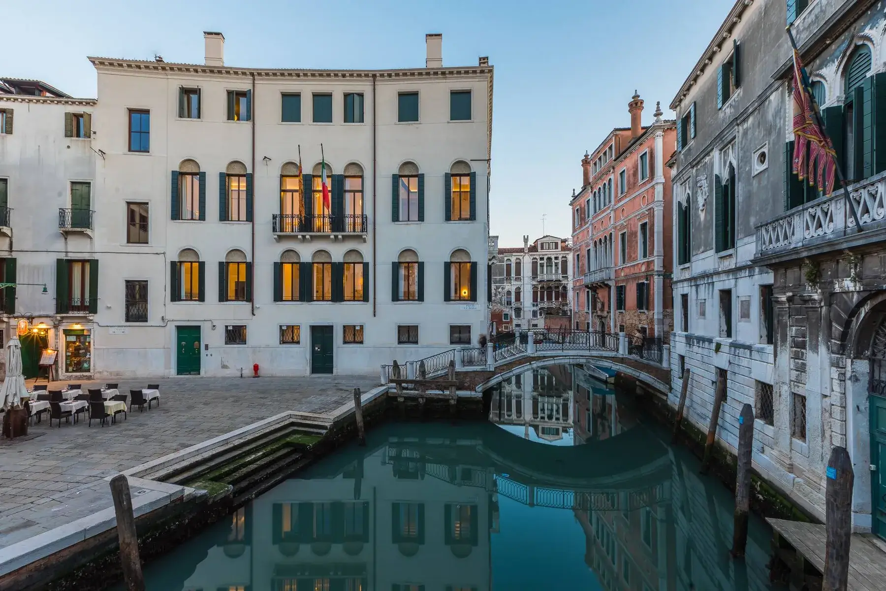 Canale di Venezia al tramonto con Palazzo Morosini degli Spezieri e un piccolo ponte.