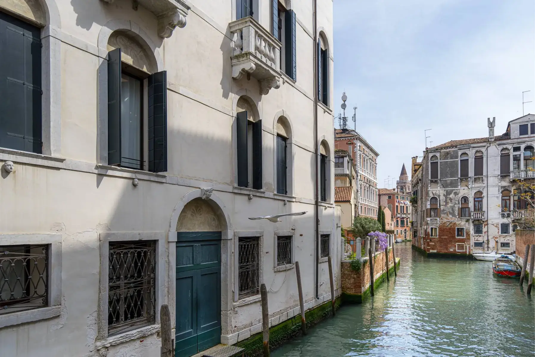 Canale di Venezia con Palazzo Morosini degli Spezieri e una piccola imbarcazione galleggiante.