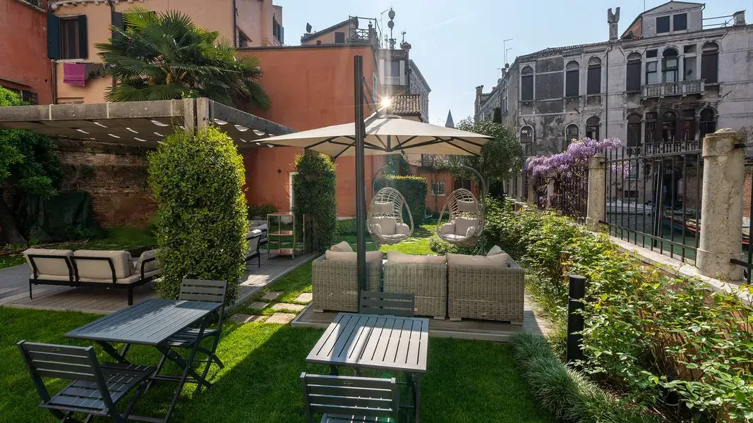 Accogliente giardino con patio, pergolato, ombrellone, verde ed Palazzo Morosini degli Spezieri tutt'intorno.